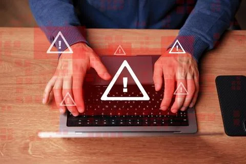 Person using a laptop while emergency 911 alerts appear on the screen Stock Photos
