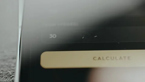 Person using a loan calculator on smartphone, close-up view Stock Footage 332508284