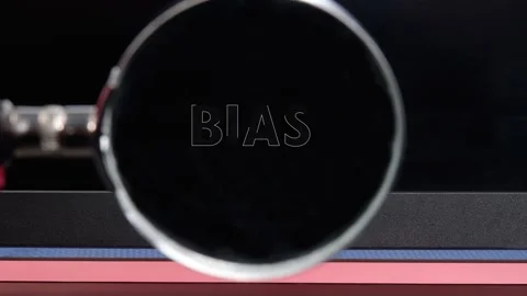 A person using a magnifying glass to focus on the word bias. The setting Stock Footage 336816770
