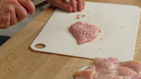 Person using meat tenderizer on raw chicken. Chef preparing pork loin slice with Stock Footage 333464174