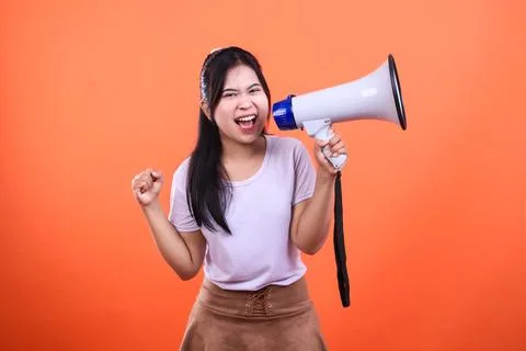 Person using a megaphone isolated on orange background expressing energy an.. Stock Photos