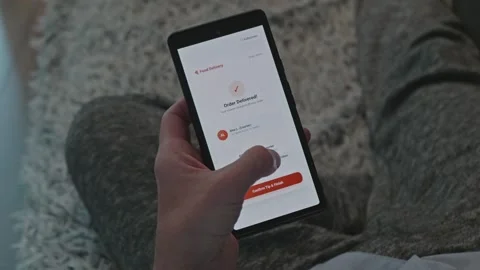 Person using a mobile app on a smartphone to leave a tip for a courier after Vidéo 341569265