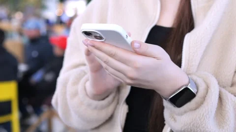 Person using mobile phone outdoors with blurred crowd background Stock Footage 341183345