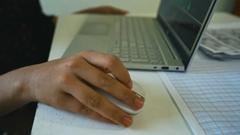Person Using Mouse with Laptop on Desk, A person using a computer mouse nex.. Stock Footage 304977571