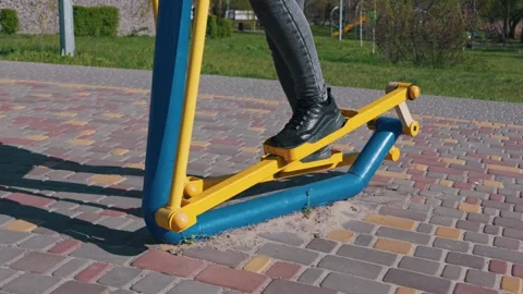 Person Using Outdoor Elliptical Exercise Machine in City Park Stock Footage 334126168