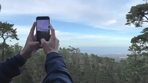 Person using the panoramic function of an iPhone 12 camera at the top of a Stock Footage 145812140