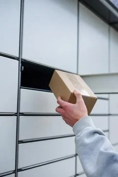 Person using parcel locker to drop off or pick up package Stock Photos
