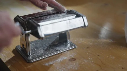 A person is using a pasta maker to make pasta Stock Footage 305983451