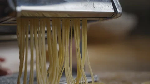 A person is using a pasta maker to make noodles Stock Footage 305983501
