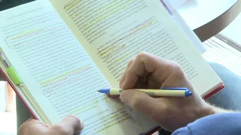 Person using a pen to follow the line he is reading in a book (1 of 2) Stock Footage 10774692