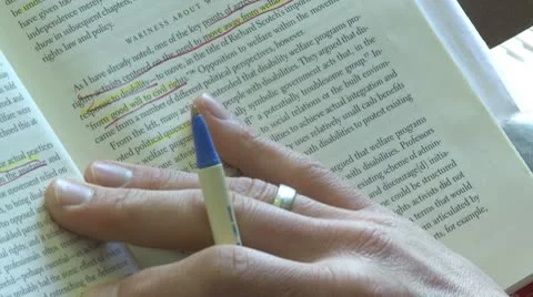 Person using a pen to follow the line he is reading in a book (2 of 2) Stock Footage 10774694