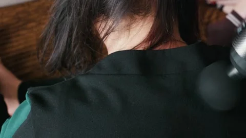 Person Using Percussive Massage Gun on Neck for Muscle Recovery Detail Stock Footage 335229277