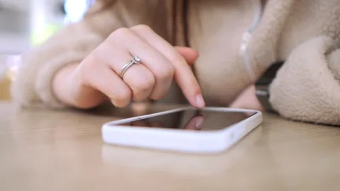 Person using phone indoors at table, fingers tapping screen Stock Footage 342056229