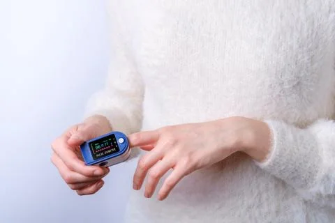 Person using pulse oximeter device on finger, healthcare monitoring concept Stock Photos