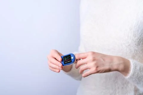 Person using pulse oximeter device on finger, healthcare monitoring concept Stock Photos