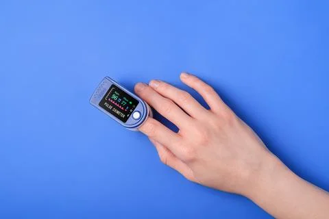 Person using pulse oximeter device on finger, healthcare monitoring concept Stock Photos