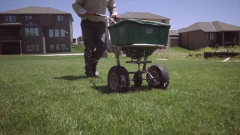 Person using a push spreader Stock-Footage 255658513