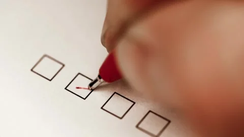 Person using red pen to check a box on printed form Stock Footage 304985372