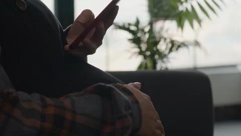 Person Using Red Smartphone Indoors with Blurred Green Plants Stock-Footage 336522776