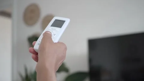 Person using remote control for television in living room Stock Footage 345184896
