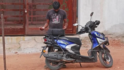 Person using right angle scale to measure camera bag on two wheeler. Stock-Footage 313023833