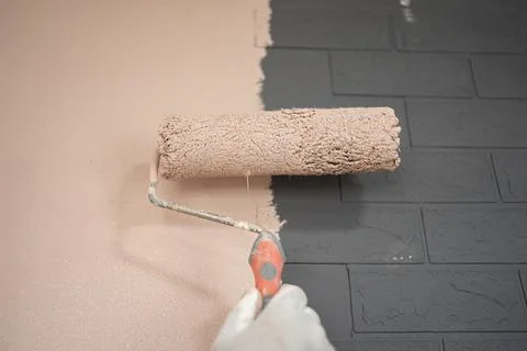Person Using Roller to Paint Wall Stock Photos
