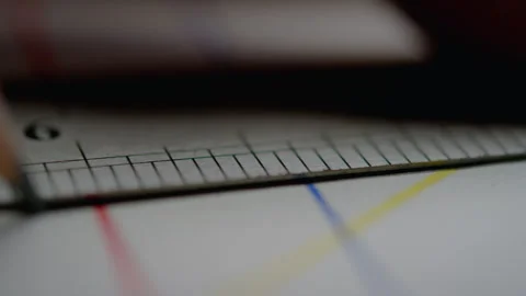 Person using a ruler to draw a line on a piece of paper Stock Footage 274582649