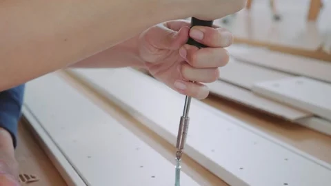 A person is using a screwdriver to put a screw into a piece of wood Stock Footage 314649590