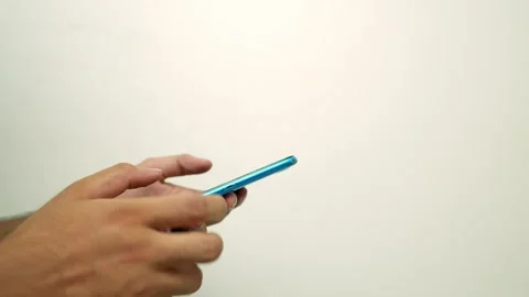 Person Using Smartphone Against Plain Background Stock Footage 315981307