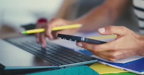 Person Using Smartphone and Laptop in Office Stock Footage 323580384