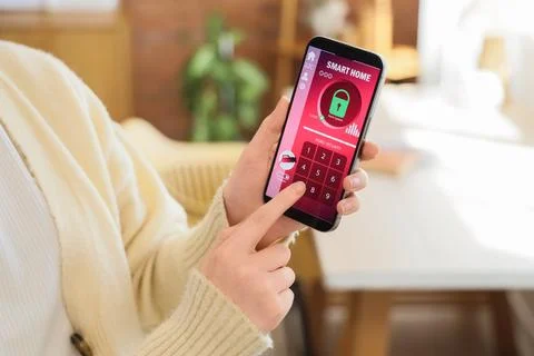 Person using smartphone app to control smart home security system Stock Photos