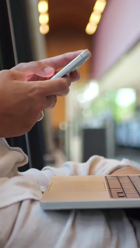 Person Using Smartphone Beside Laptop in Modern Workspace... Stock Footage 344455142