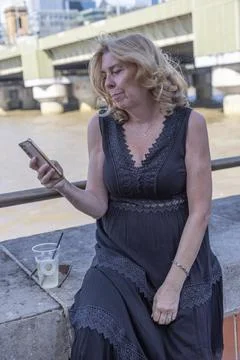 Person Using Smartphone Beside the River Thames in London Stock Photos