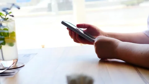 Person Using Smartphone at a Caf Table Stock Footage 311872055