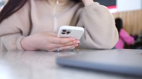 Person using smartphone in casual indoor setting, with laptop nearby Stock Footage 343579646