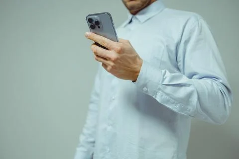 Person using a smartphone, close-up view of hands holding a dark gray devic.. Stock Photos
