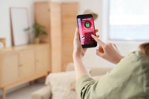 Person using smartphone to control smart home security system Stock Photos