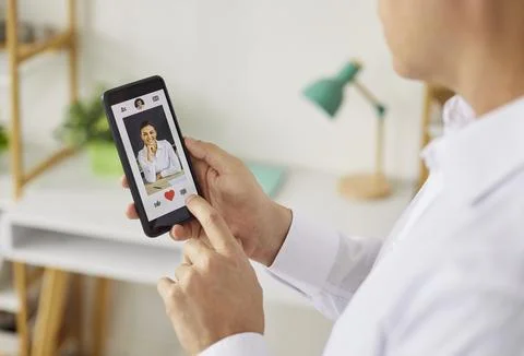 Person using smartphone dating app to like a profile with heart icon closeup Stock Photos