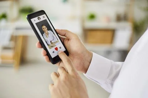 Person using smartphone dating app to like a profile with heart icon closeup Stock Photos