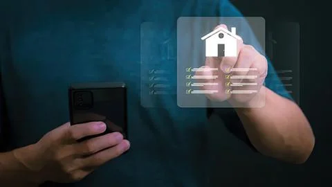Person using smartphone with digital house icon overlay Stock Photos