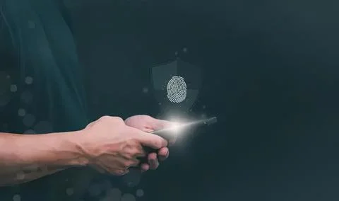 Person using smartphone with fingerprint security in dark Stock Photos