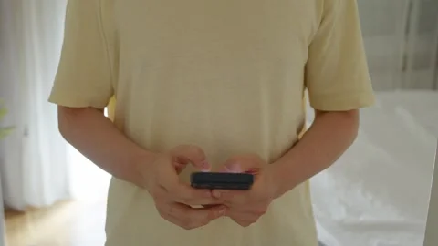 Person using smartphone indoors for communication 動画素材 340296314