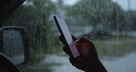Person Using Smartphone Inside Car During Heavy Rain With... 库存影片 332075302