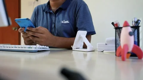 Person Using Smartphone at Office Desk, Person using smartphone at a desk w.. Stock Footage 317736979