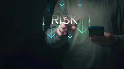 Person using smartphone with risk and downward arrows Stock Photos