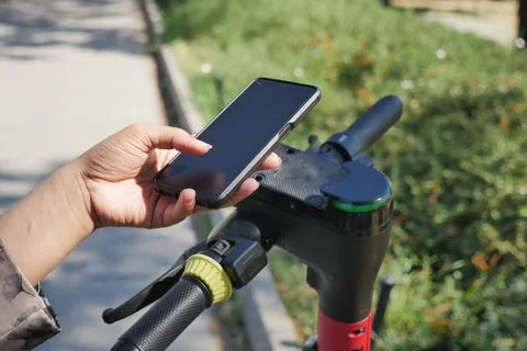 Person Using Smartphone to scan the QR code to unlock Electric Scooter for a Stock Photos