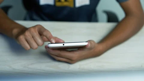 Person using a smartphone at a table, Close-up of a person using a smartpho.. Stock-Footage 346484176