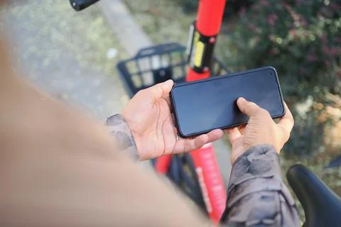 Person Using Smartphone To Unlock Shared Electric Scooter App While Preparing Stock Photos