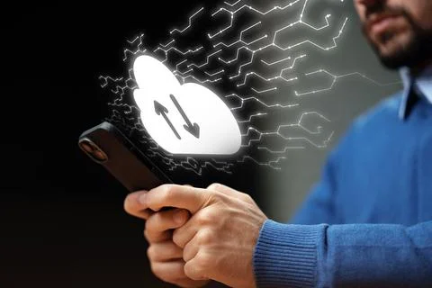 Person using smartphone to upload data to a cloud service in a dark setting Stock Photos