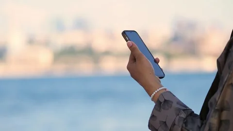 Person using smartphone by the water 스톡 동영상 341068881